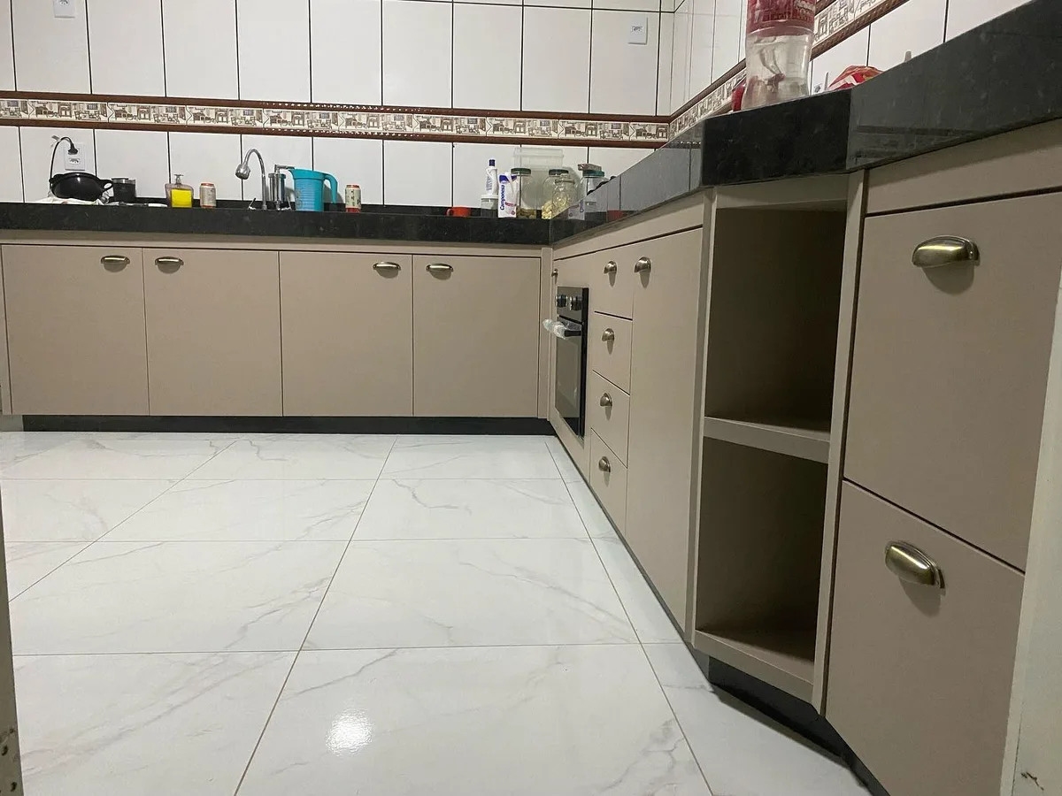Cozinha com armários em tom fendi, nichos abertos e torre de forno